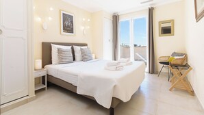 Un dormitorio con cama, mesita de noche y una silla.