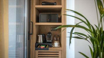 Eine kleine Küche mit Mikrowelle, Kaffeeautomat und Tee-/Kaffeeausgabe.