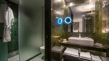 Une salle de bain moderne avec une douche à parois de verre, un lavabo blanc et un grand miroir.