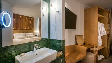 A modern bathroom with a large mirror, a sink, and a wooden vanity.