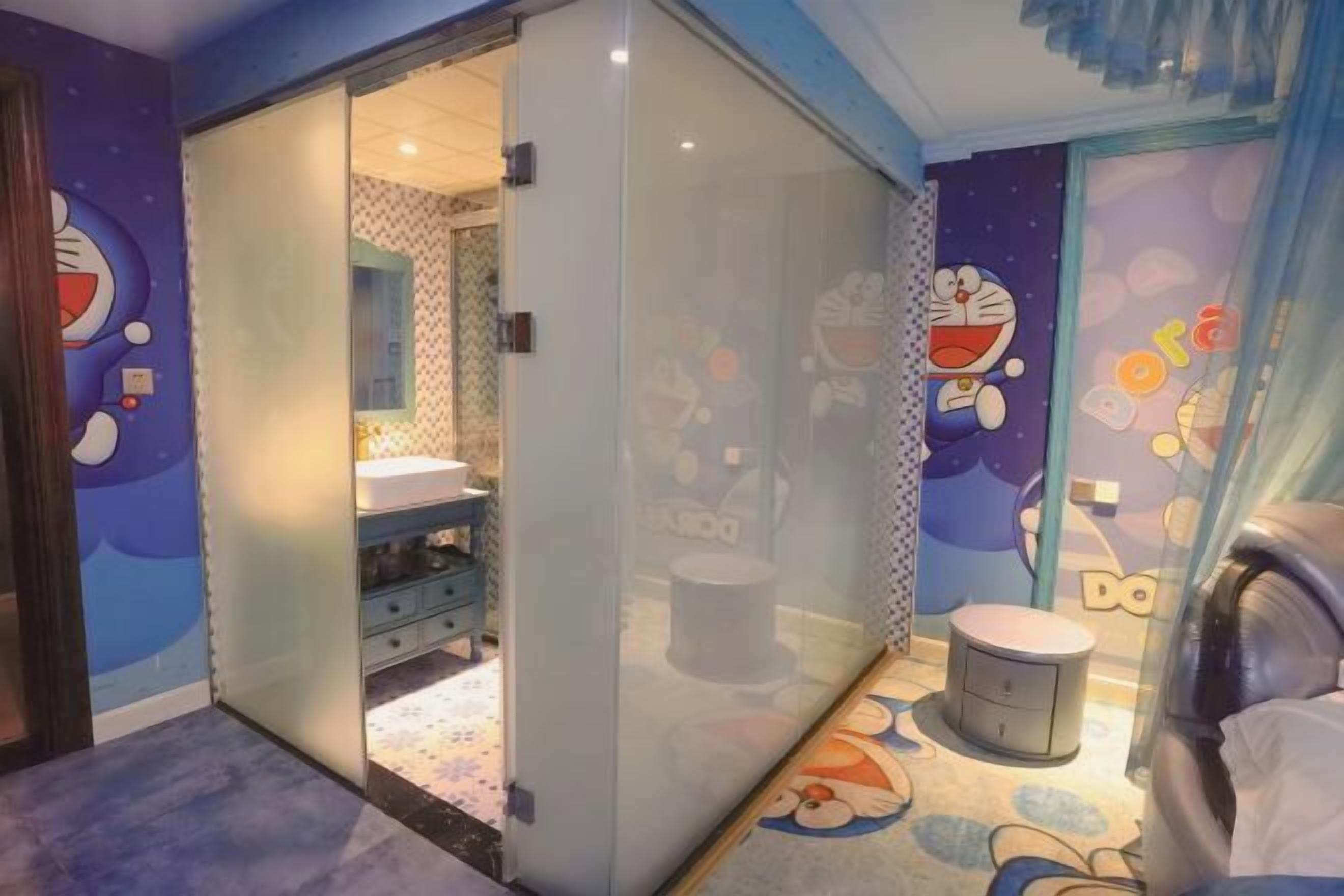 Ein Kinderzimmer mit einer Schiebetür zu einem Badezimmer, einem kleinen runden Hocker und Wandbildern mit einer Zeichentrickfigur.