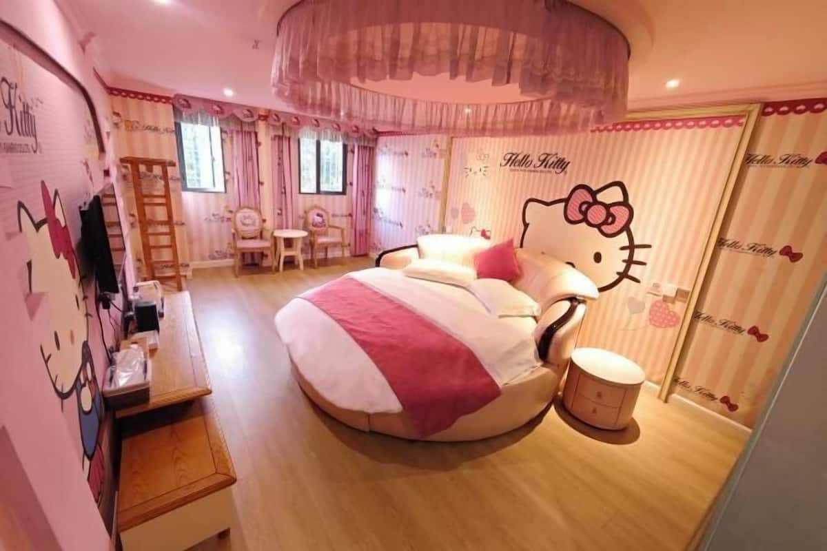 Ein Zimmer mit einem Hello Kitty betten-Thema, einem kleinen Schreibtisch und einem Stuhl.