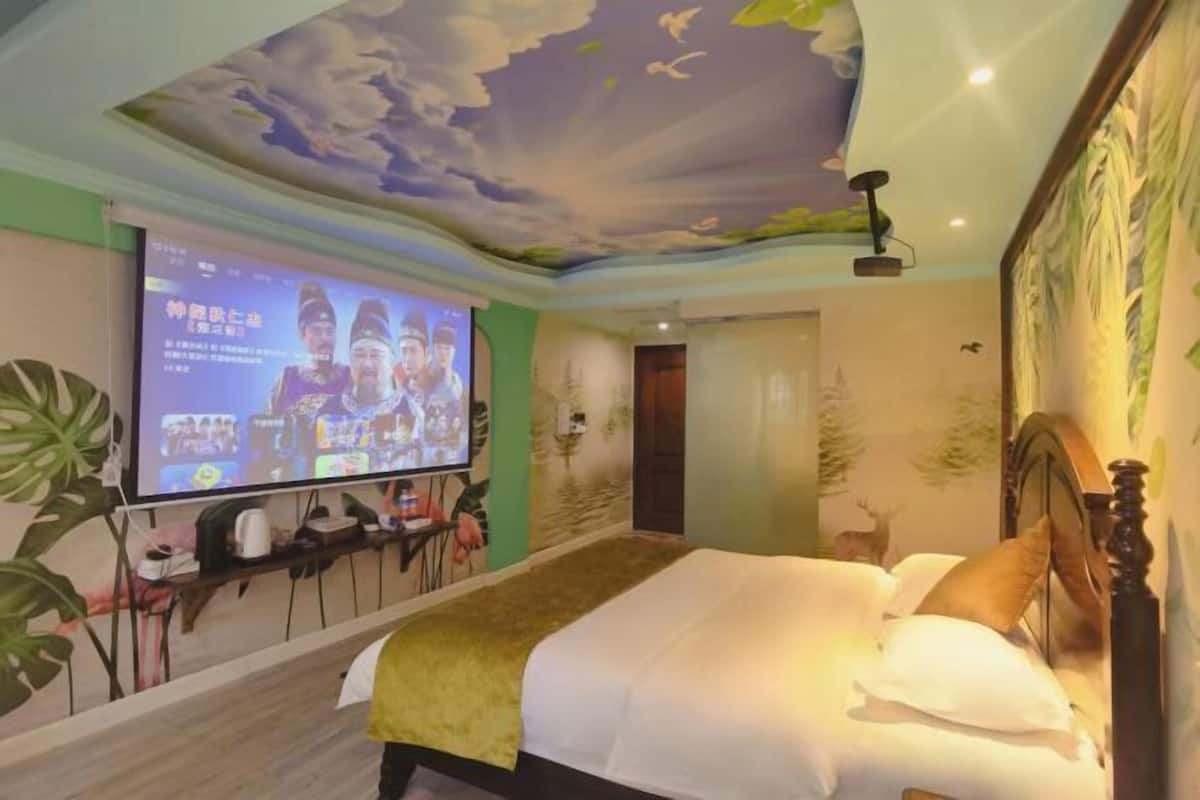 Ein Hotelzimmer mit einem Bett, einem an der Wand montierten Fernseher und einem Deckenfresko.