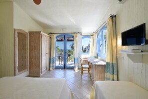 Una habitación de hotel con balcón, televisión y cama.