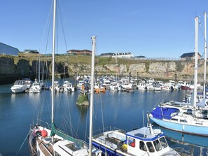 A marina with multiple boats docked, a rocky shoreline, and buildings in the background. - 3 bedroom accommodation in Seaham (Seaham)