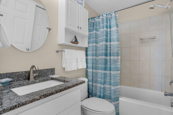 Un baño con lavamanos, inodoro y bañera.