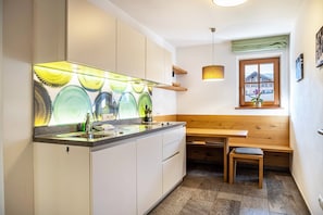 A kitchen with a large island, wooden bench, and a window with a view.