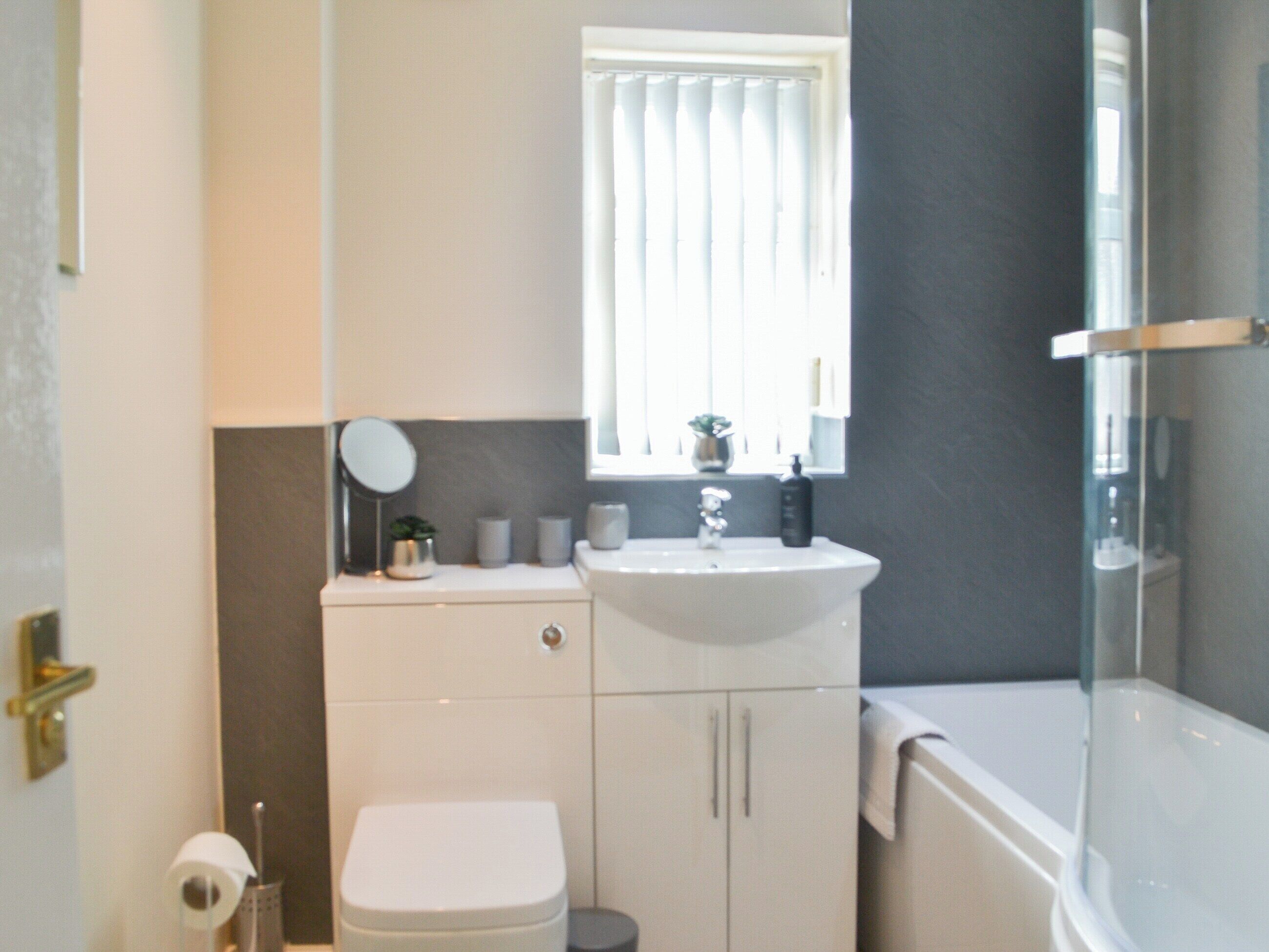 A bathroom with a toilet, sink, and bathtub.