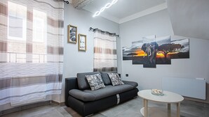 A modern living room with a sofa, a small table, and artwork on the wall.
