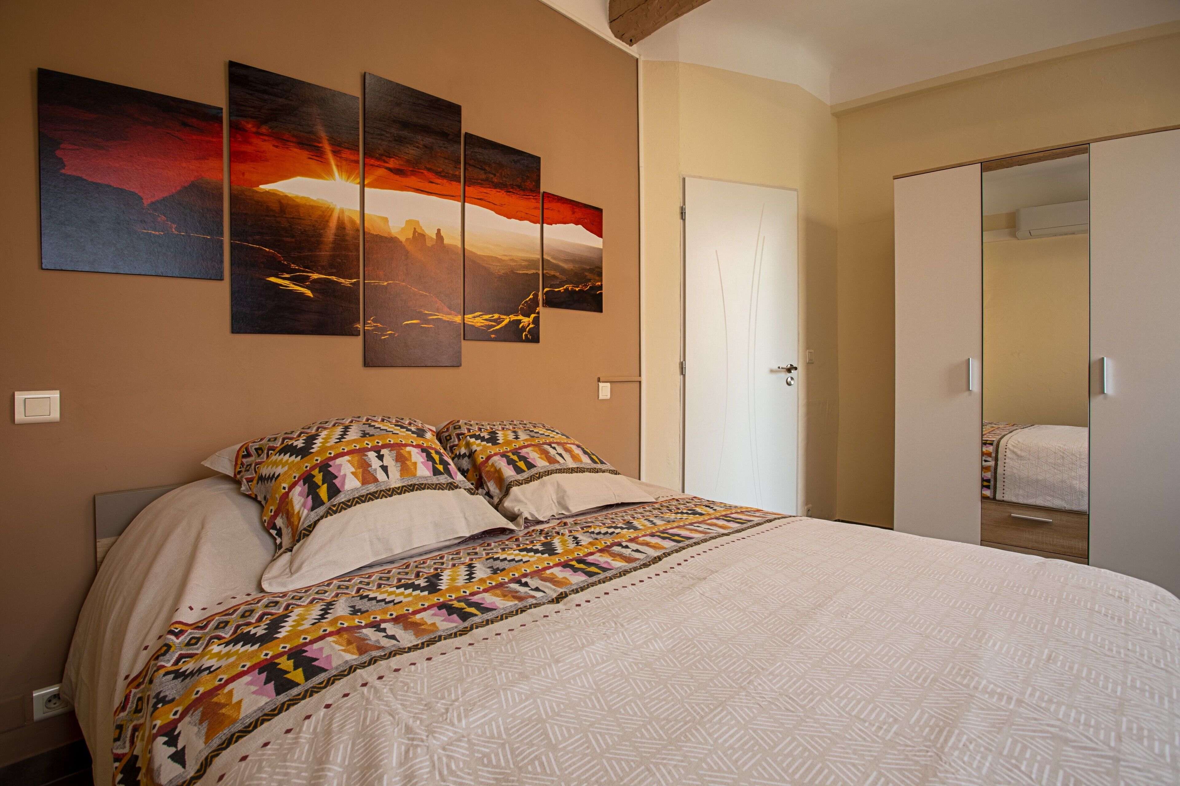 A bedroom with a bed, a wardrobe, and a door.