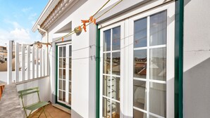 A building with white exterior walls, green-framed windows, and a green metal bench. - Holiday Apartment "Tourismer Centro" in City Center with Shared Terrace & Wi-Fi (Lagos)