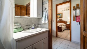 Een badkamer met een wastafel, spiegel en houten kastjes.