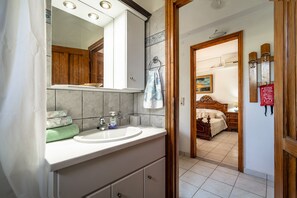 A bathroom with a sink, mirror, and wooden cabinets.