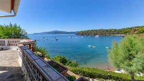 A coastal view with boats, a clear sky, and a stone staircase leading down to a beach. - Apartment 'Villa Oda - Monolocale Sul Mare' with Sea View, Wi-Fi and Air Conditioning (Capoliveri)