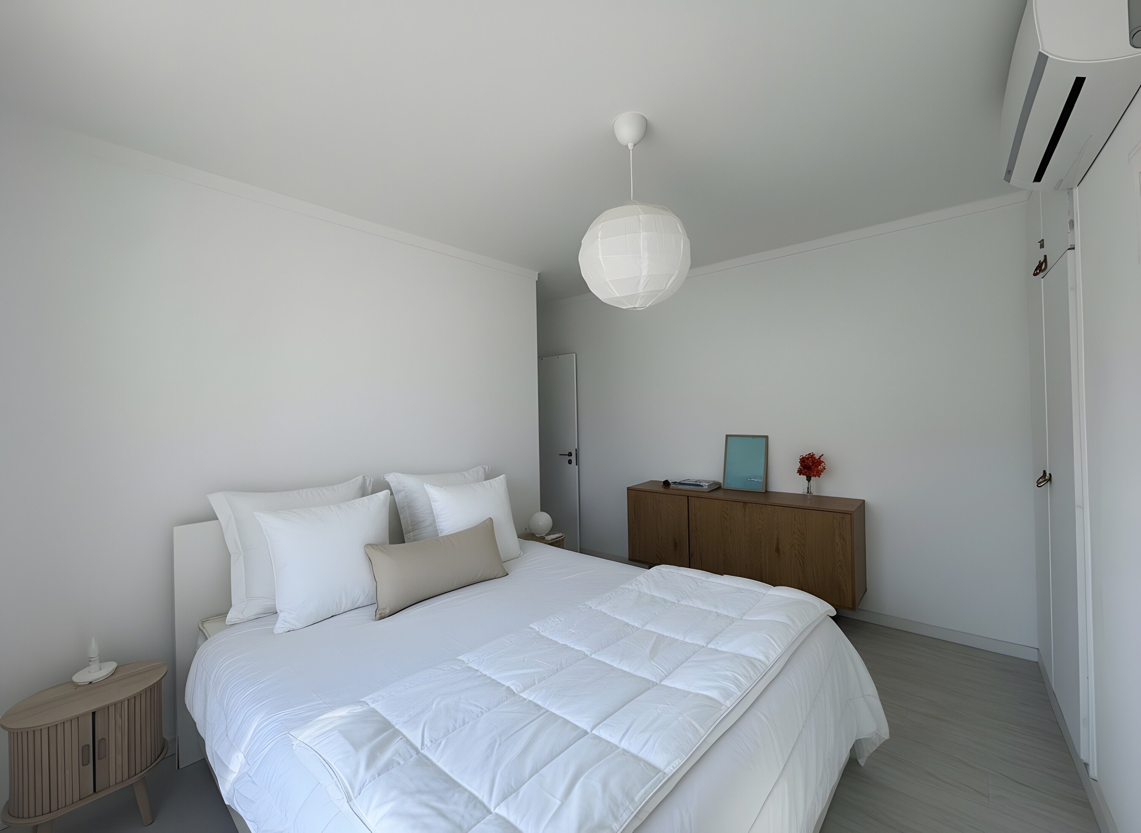 A bedroom with a bed, bedside table, dresser, and an air conditioning unit.