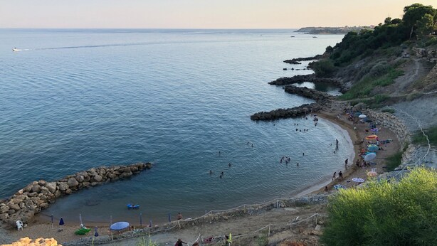 A coastal beach with rocky formations, clear blue water, and people enjoying the area. - Holiday Apartment "Capo Rizzuto 2" with Sea View, Private Terrace & Wi-Fi (isola di capo rizzuto)