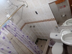 A bathroom with a shower, toilet, and sink. - DEPARTAMENTO 7 (Quito)