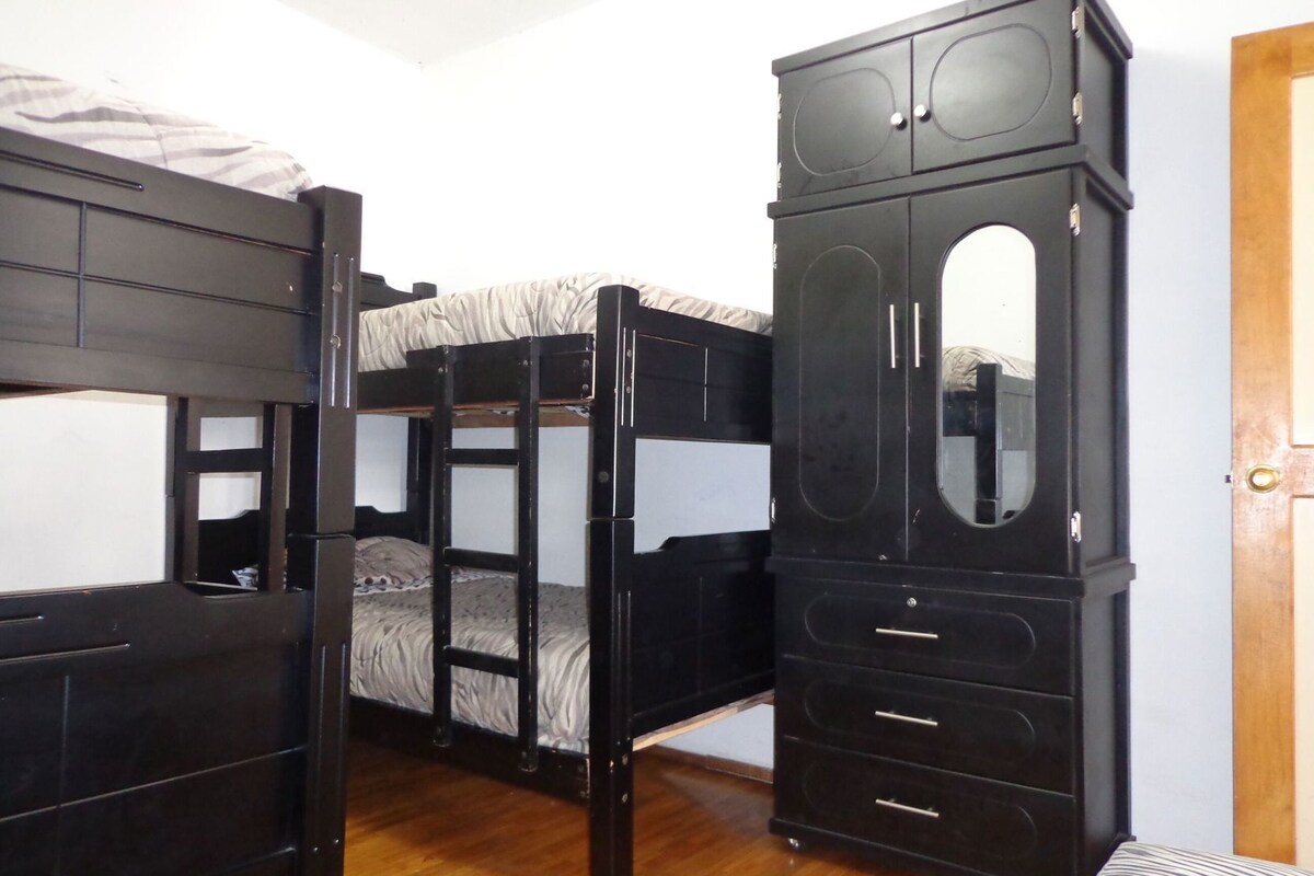 Un lit superposé avec une armoire et un miroir.