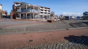Een modern gebouw met een café en restaurant op de begane grond, met een glazen gevel en een golvend ontwerp.