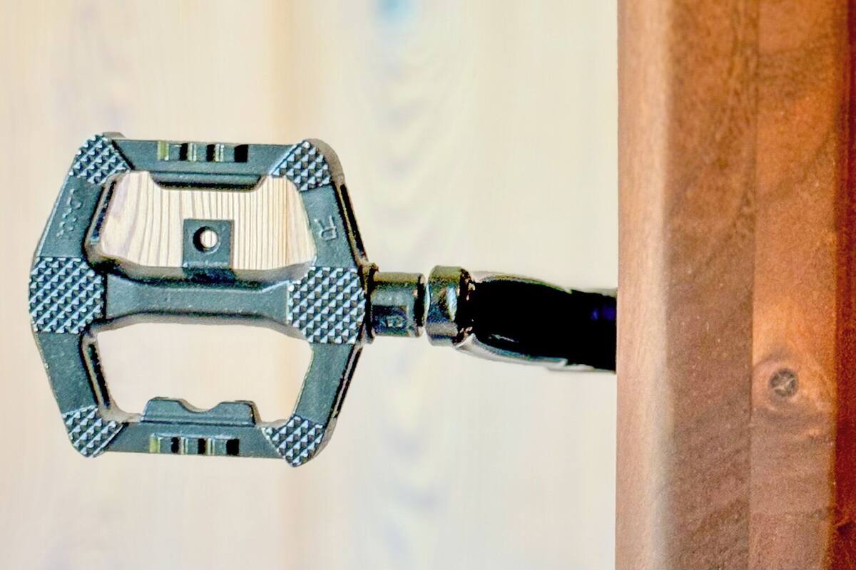 A close-up of a bicycle pedal attached to a wooden structure.