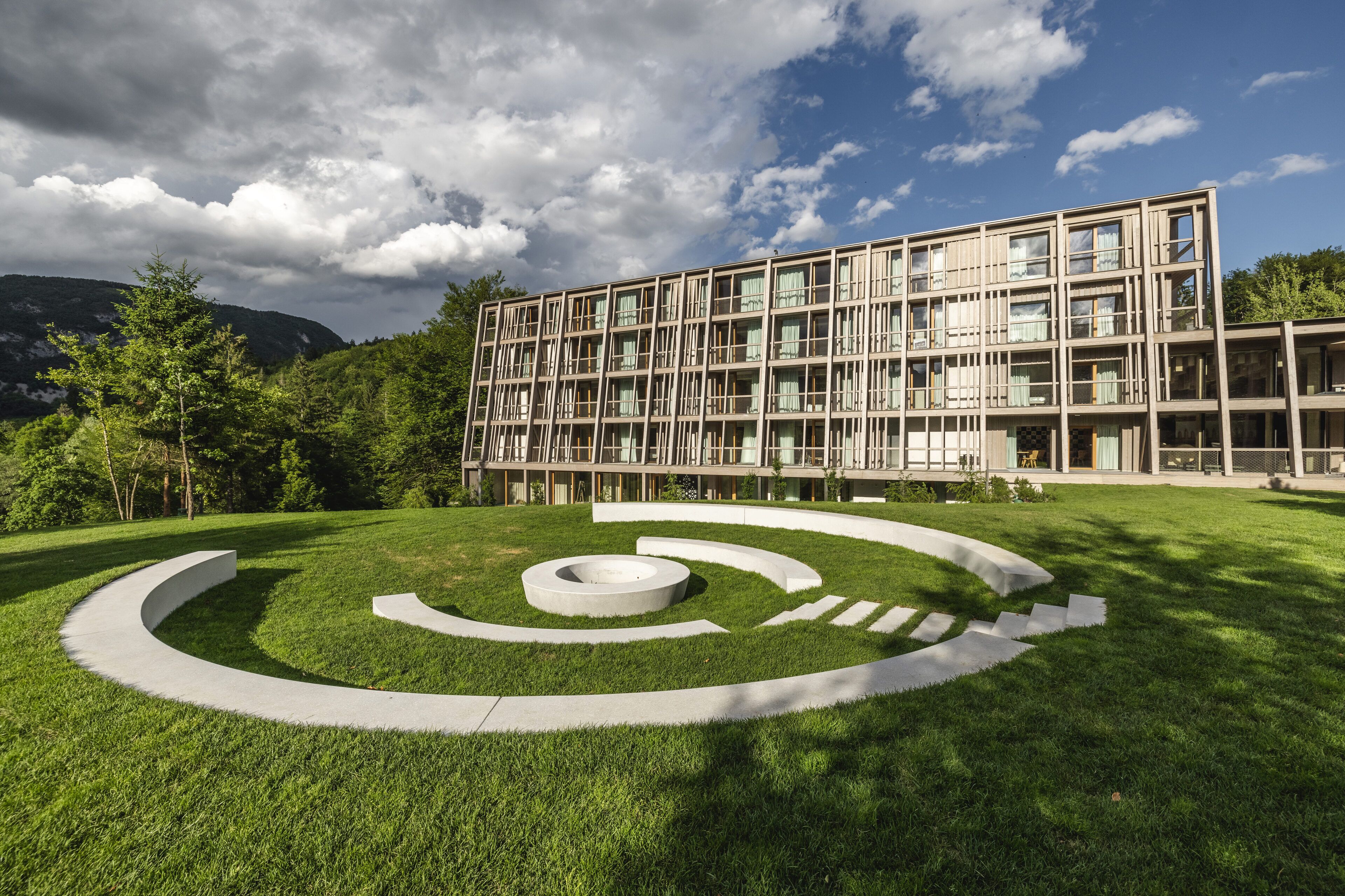 A modern building with a glass facade and a landscaped area with a circular design.