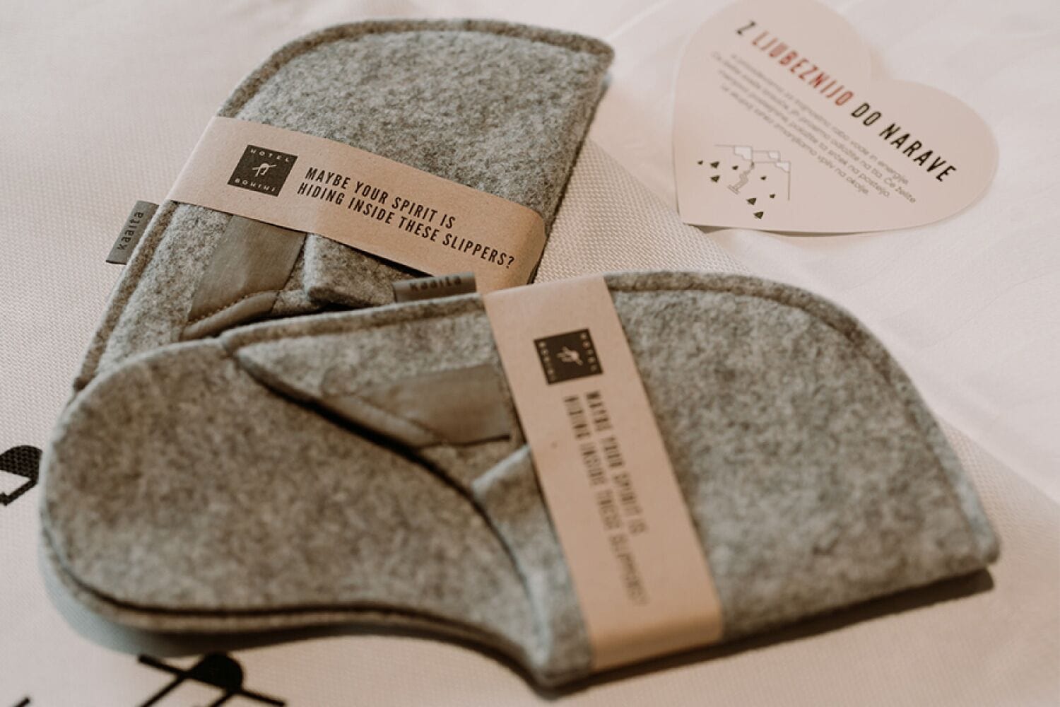 A pair of slippers with a tag that reads "Maybe your spirit is hiding inside these slippers?" and a card with the text "Luz do Narave".