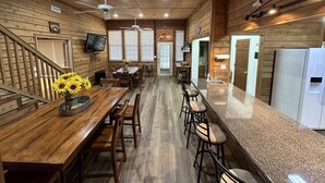 Een houten interieur met een keuken, eethoek en bar.