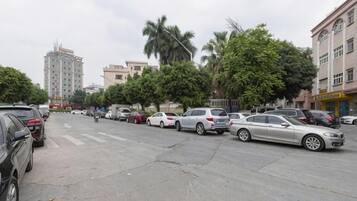 A parking lot with multiple cars, a pedestrian crossing, and buildings in the background.