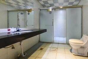 A bathroom with a sink, mirror, toilet, and a shower enclosure. - Dongguan Xinyi Business Hotel (Xingtai Academy) (Dongguan)