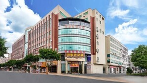 A multi-story hotel with a curved glass facade, a ground-level restaurant, and a visible entrance.