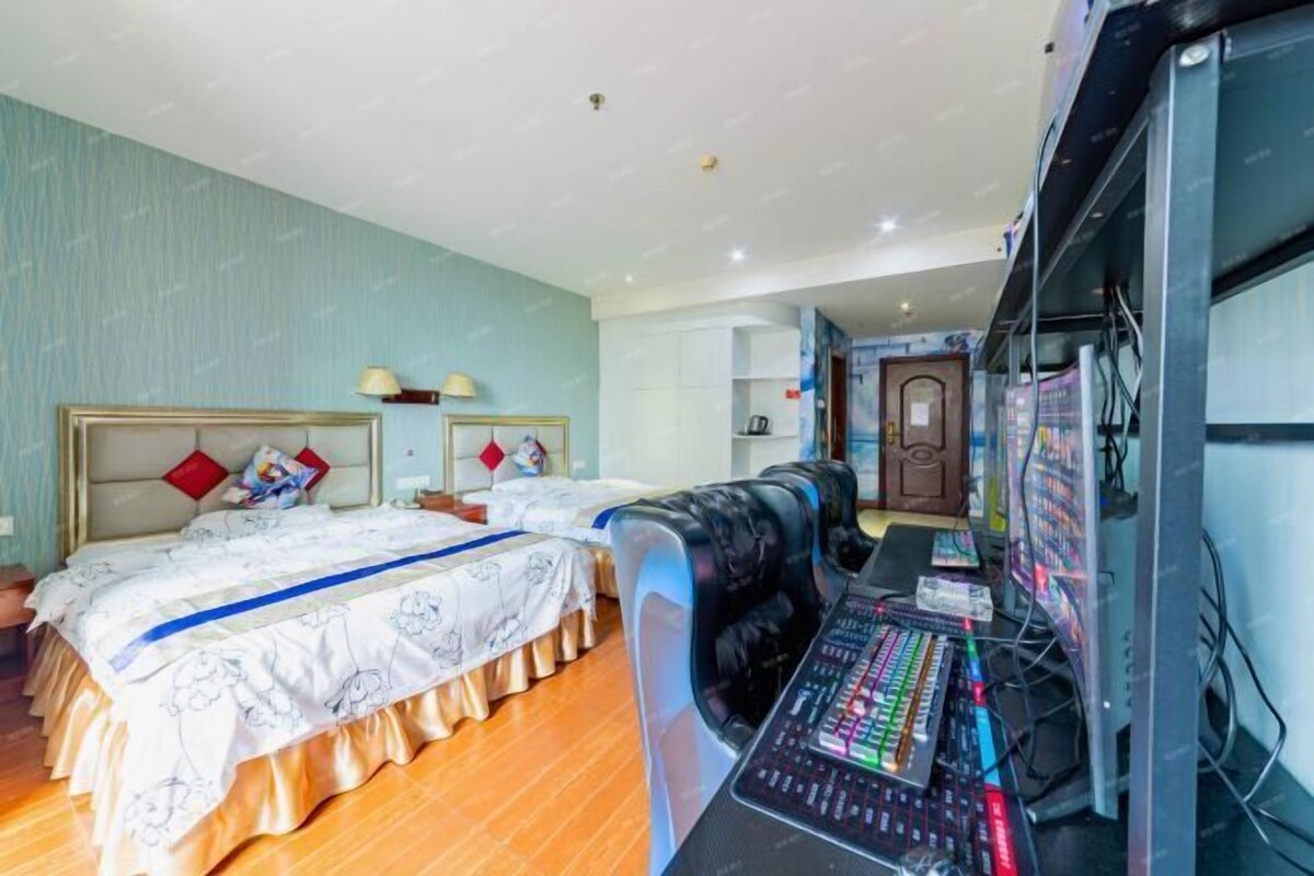 A hotel room with two beds, a sound mixing console, and a kitchenette.