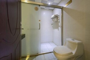 A small bathroom with a toilet, a shower, and a glass door. - Dongguan Xinyi Business Hotel (Xingtai Academy) (Dongguan)