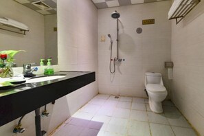 A small bathroom with a shower, toilet, and sink. - Dongguan Xinyi Business Hotel (Xingtai Academy) (Dongguan)
