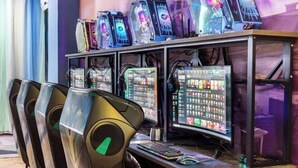 A gaming setup with multiple monitors, gaming chairs, and a desk.