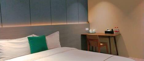 A hotel room with a bed, a desk, and a chair.