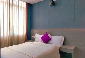 A hotel room with a bed, a nightstand, and a wall-mounted projector. - Youjian Inn (Guangzhou University Town) (Guangzhou)