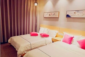 A hotel room with two beds, each with white bedding and pink pillows. There are two framed artworks on the wall, a wooden nightstand, and a window with curtains. - Youjian Inn (Guangzhou University Town) (Guangzhou)