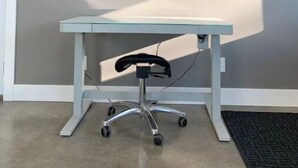 A modern office space with a glass desk, a black chair, and a mounted flat-screen TV on the wall. - Luxury shome, views above Skagit Valley- EV charge (Mount Vernon)