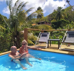 Un espace piscine avec des chaises longues et une terrasse en bois.