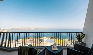 Un balcon avec vue sur la mer et un espace de stationnement.