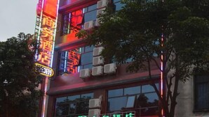 A hotel with a prominent neon sign indicating it is a business hotel.