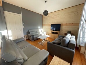 A modern living room with a sofa set, a coffee table, and a television. - Bright nest with mountain view in Gérardmer (Gérardmer)