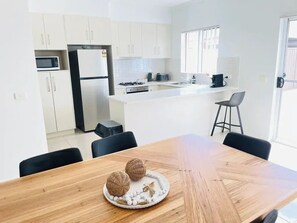 Enjoy cooking in this well-equipped kitchen with a refrigerator, microwave, and stove, and dine at the adjacent table with comfortable seating for two.