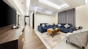 A modern living room with a sofa set, a coffee table, and a TV. - Luxury Night Al Munsiyah (Riyadh)
