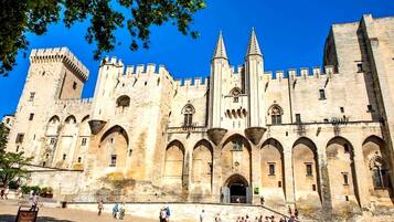 A historic castle with multiple towers, arched windows, and a central entrance.
