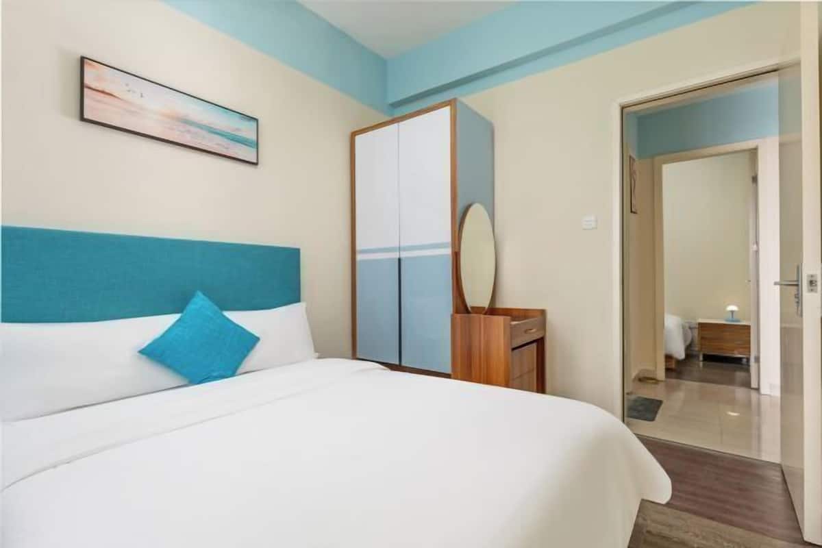 Une chambre bien rangée, avec un lit, une armoire et un miroir.