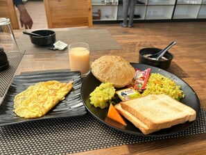 Un piatto da colazione con un'omelette, pane tostato e verdure.