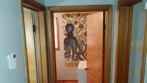 A hallway with wooden doors, a white radiator, and a wall with an octopus mural.