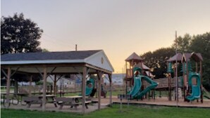 A playground with slides and a covered picnic area.