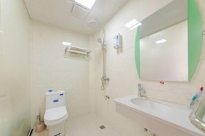 A small, clean bathroom with a toilet, sink, and shower. - Youpeng Holiday Hotel (Yangxin)